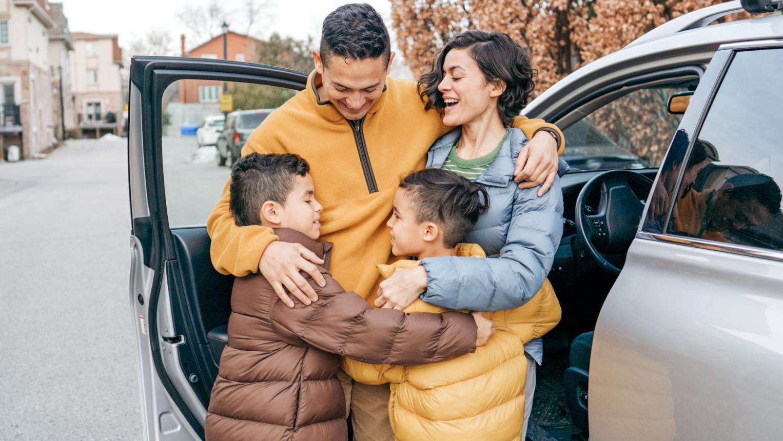 Ontario family next to their vehicle and home